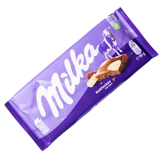 Milka Cow Spots Kuhflecken alpine milk chocolate bar, 3.17 oz, front wrapper in purple with cow and chocolate piece shown